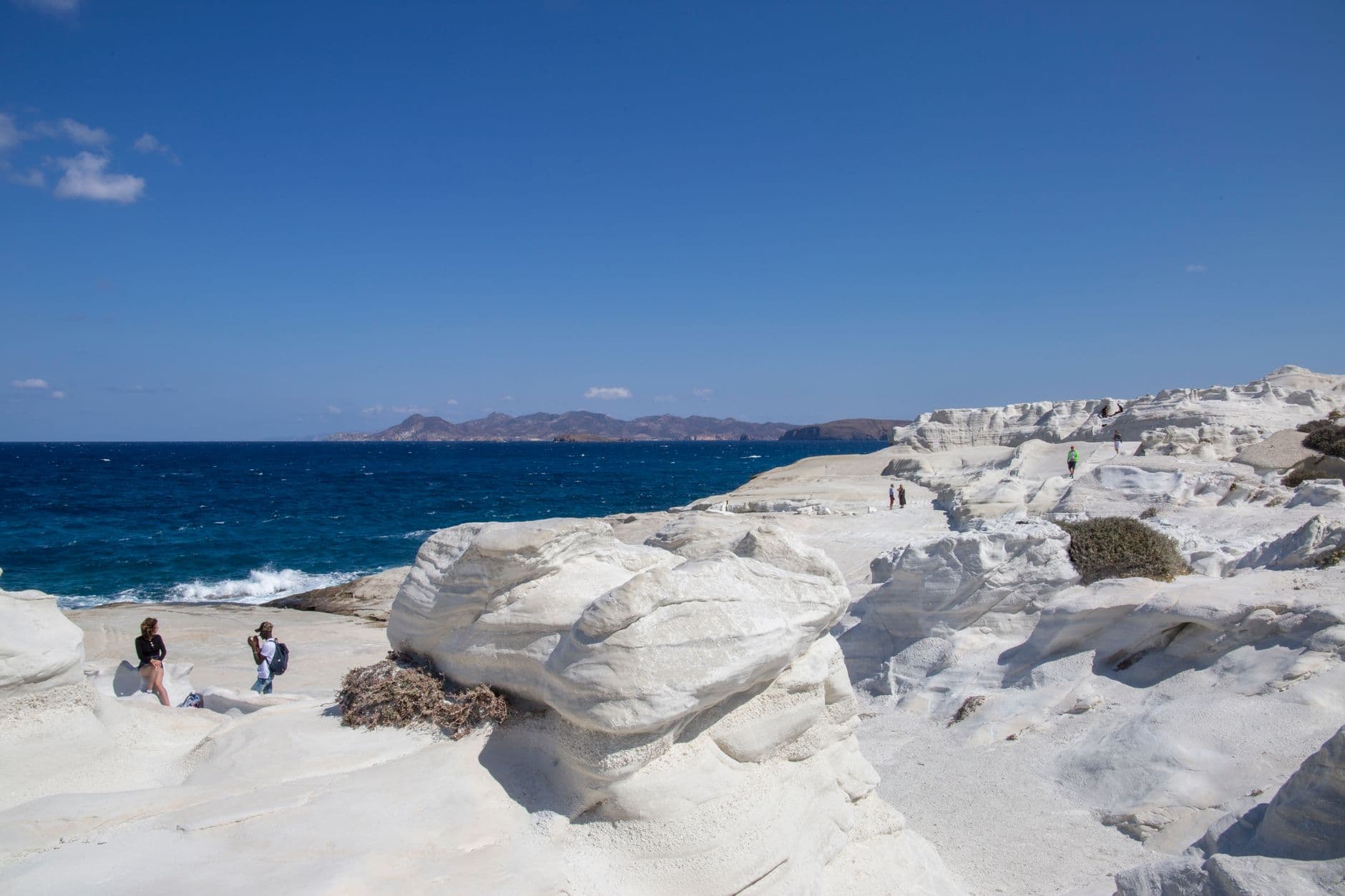 White rock formations along the Milos coastline under a clear sky